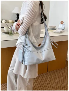 Slouchy light blue soft leather hobo bag styled in a minimalist cafe setting.