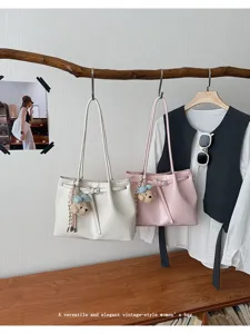 Vue détaillée du grand sac cabas en cuir souple avec ceinture élégante et breloque ours.