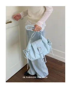 Close-up of a stylish light blue nylon shoulder bag featuring a classic buckle flap design