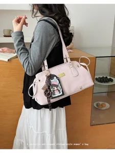 Elegante rosa Vintage-Umhängetasche für Damen mit stilvollen Anhängern in Lifestyle-Umgebung