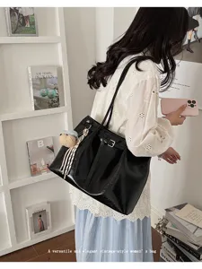 Vue détaillée d'un élégant sac cabas noir grande capacité avec boucle dans un décor de style
