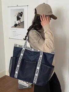 Große dunkelblaue Tragetasche mit Netztaschen und Riemen mit Buchstaben für den Alltag