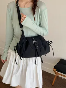 Casual black nylon crossbody bag with belt buckle flap and decorative side drawstrings