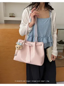 Vue détaillée du cabas en cuir souple rose avec un design de ceinture vintage et un charm ours