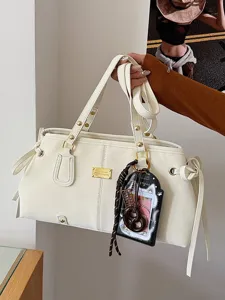 Elegante cremeweiße Retro-Schultertasche mit Nähten und süßem Katzenanhänger-Accessoire