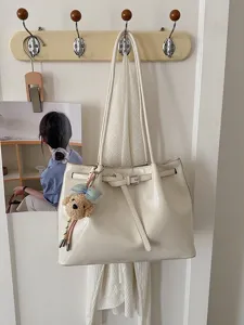 Grand sac cabas beige en cuir souple avec ceinture décorative et breloque petit chien.