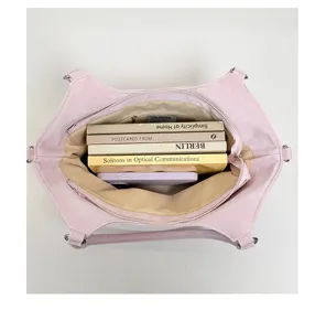 Gedetailleerd overzicht van de ruime roze draagtas gevuld met diverse boeken en mobiel