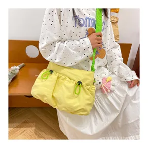 Candy yellow canvas messenger bag with bright green strap and drawstring pocket.