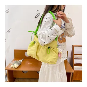 Side view of a pale yellow industrial style canvas tote bag with neon green drawstrings