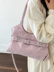Minimalistische roze crossbody draagtas met decoratieve gesp gedragen door model
