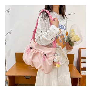 Pink utilitarian drawstring tote bag with ruffled strap and cute bear charm detail