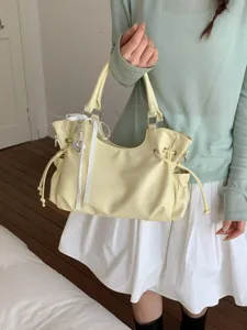 Minimalistische cremegelbe Tragetasche aus weichem Leder mit einer gepunkteten Schleife