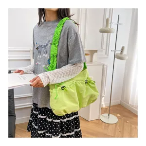 Model wearing a bright lime green canvas drawstring messenger bag in workwear style