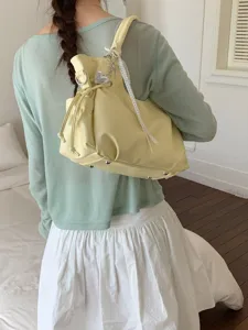 Minimalistische hellgelbe Schultertasche aus weichem Leder mit Herzanhänger