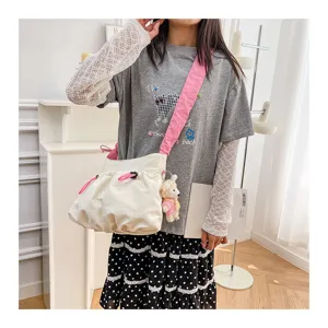 Detailed view of the workwear style canvas messenger bag with pink drawstring and strap
