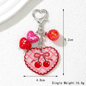 Détail du porte-clés cerise en forme de cœur avec dimensions de 9,2 cm et 4,8 cm poids 16,4 g