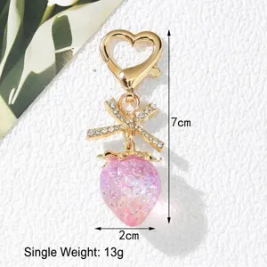 Detail view of sweet pink strawberry keychain with rhinestone bow and heart clasp