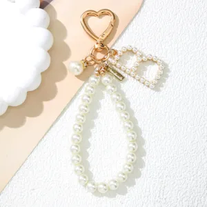 Detailed close-up of a pearl initial D keychain featuring a gold heart clasp and beads