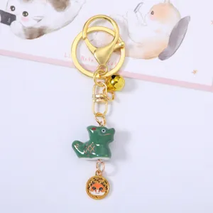 Detail of Chinese zodiac dragon ceramic keychain with gold bell and charm