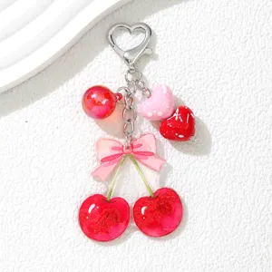 Détail d'un adorable porte-clés cerise rouge avec des breloques en forme de cœur