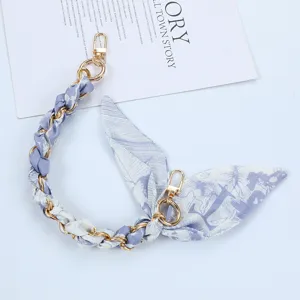 Detail view of elegant floral silk scarf phone chain with dual gold lobster clasps