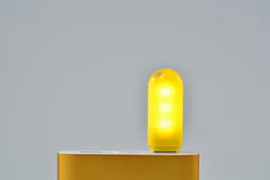 Primo piano di una luce notturna USB gialla brillante con 3 LED collegata a power bank.