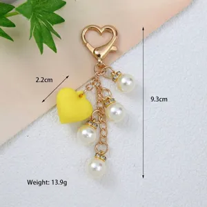 Gros plan détaillé d'un porte-clés en forme de cœur avec perles et breloque jaune