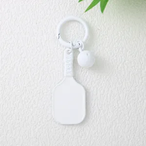 Gros plan détaillé d'un élégant porte-clés minimaliste blanc en forme de raquette de pickleball
