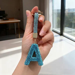 Detailed macro view of blue rhinestone letter A keychain showing weight and size data
