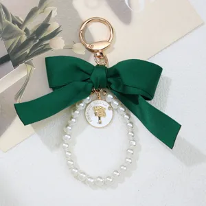 Elegant dark green bow keychain with white pearls and vintage fashion trend pendant