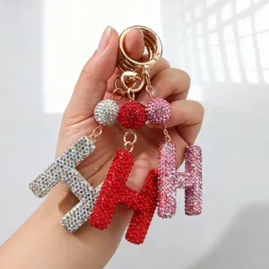 Gros plan de porte-clés lettre H étincelants ornés de strass en rouge, rose et argent.