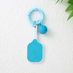Vue détaillée d'un porte-clés raquette de pickleball bleu avec un mini pendentif balle