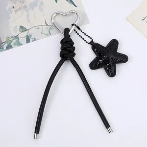 Close-up detail of black PU leather rope keychain with heart carabiner and star charm