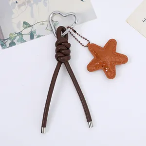 Close-up of brown PU leather rope keychain with orange starfish charm and heart clip
