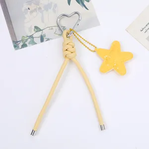 Detailed view of yellow PU leather braided cord with silver heart carabiner and star charm