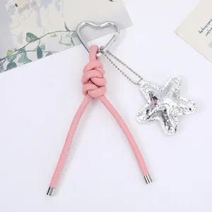 Close-up of pink PU leather braided keychain with heart carabiner and star charm