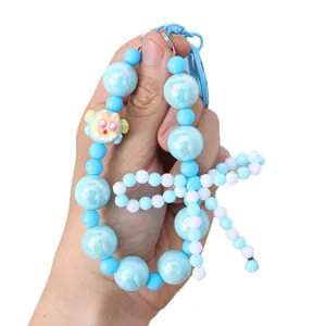 Blue pearl beaded phone charm featuring a handmade bow and cute yellow monster bead