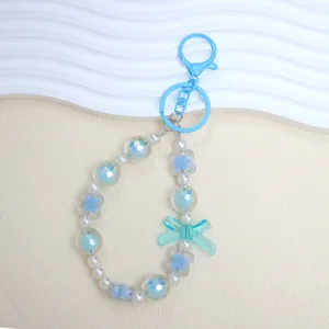 Light blue beaded phone charm with bow and lucky clover elements for bag decoration