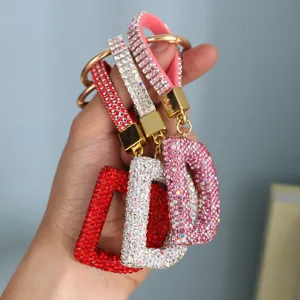 Close-up of crystal-encrusted letter D keychains in red, silver, and pink sparkly colors