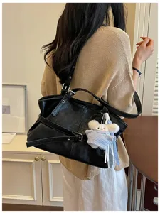 Detailansicht einer schwarzen Crossbody-Tasche im koreanischen Stil mit dekorativen Schnallen.