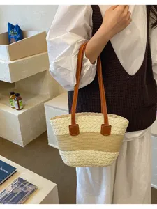 Sac cabas en paille tissée avec anses en cuir marron dans un cadre de café décontracté