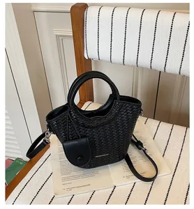 Close-up of a stylish black woven texture bucket bag featuring round top handles