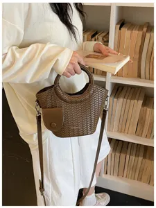 Detailed view of the brown woven texture bucket bag with round handle and side pouch