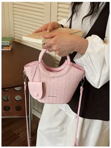 Stylish pink bucket bag with woven texture and round top handles for daily commuting