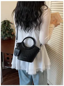 Elegant black woven bucket bag with circular handles shown on a model for commute