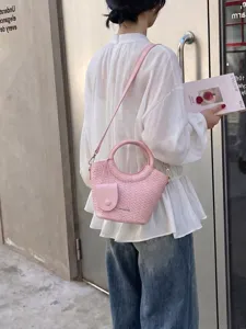 Pink woven bucket bag with round handle and detachable shoulder strap for women.