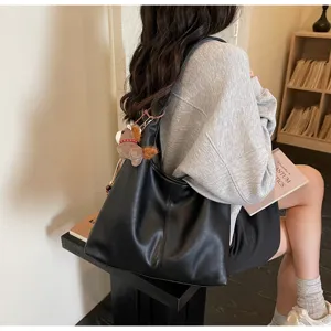 Gros plan d'un grand sac cabas en cuir souple noir porté comme sac à bandoulière chic