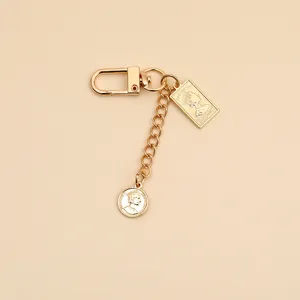 Detail showing gold vintage alloy keychain with Elizabeth II coin pendants