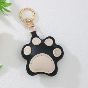 Close-up of cute black and beige leather cat paw keychain with gold-tone metal clasp