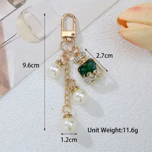 Detalle del llavero con forma de frasco de perfume de cristal verde con perlas